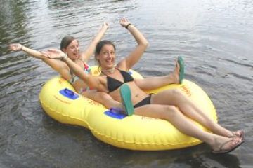 a woman sitting next to a body of water