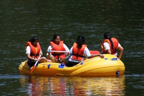 a group of people riding on the back of a boat in the water