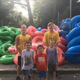 a group of people standing in front of a fruit stand