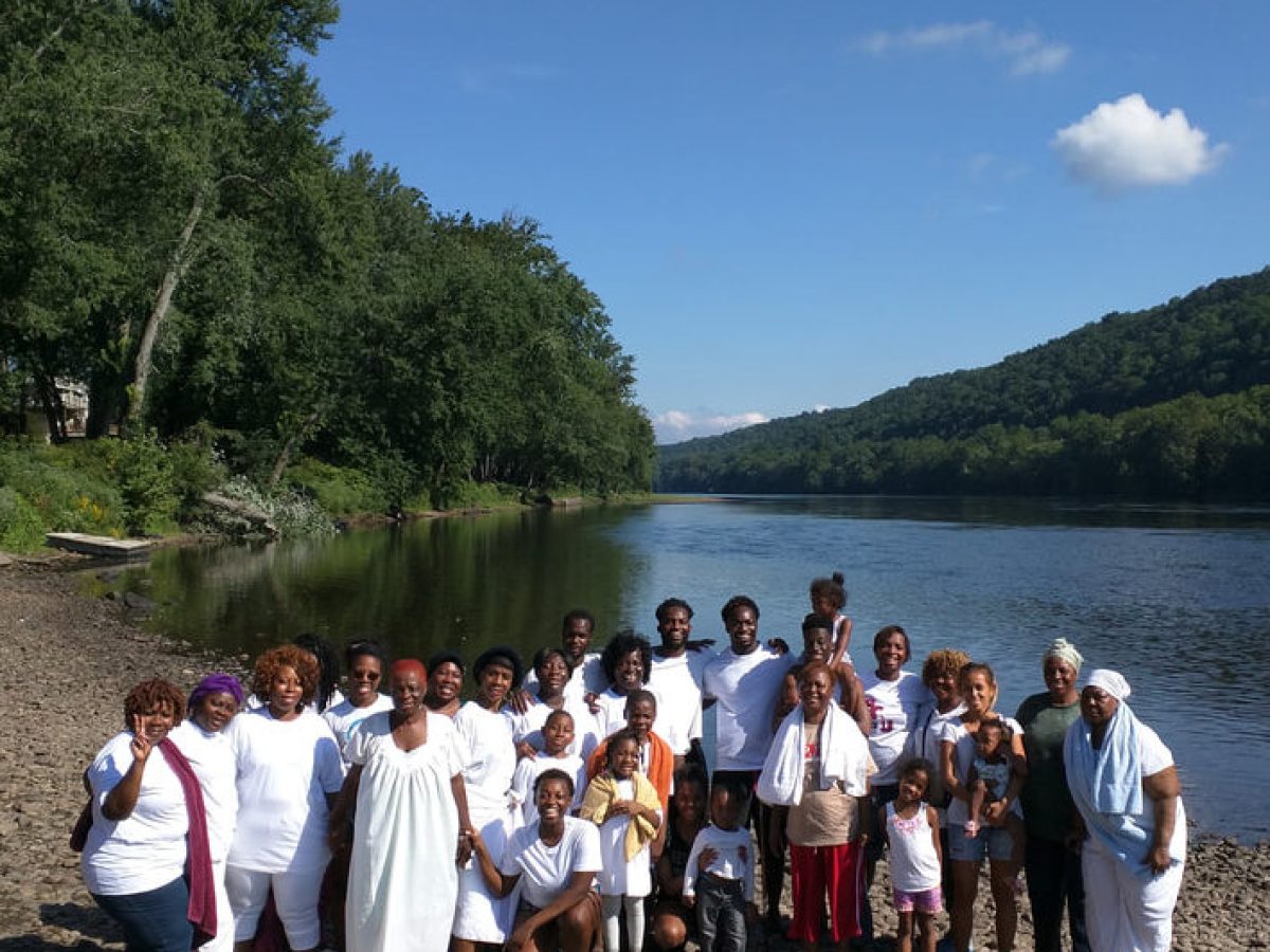 a group of people standing next to a lake