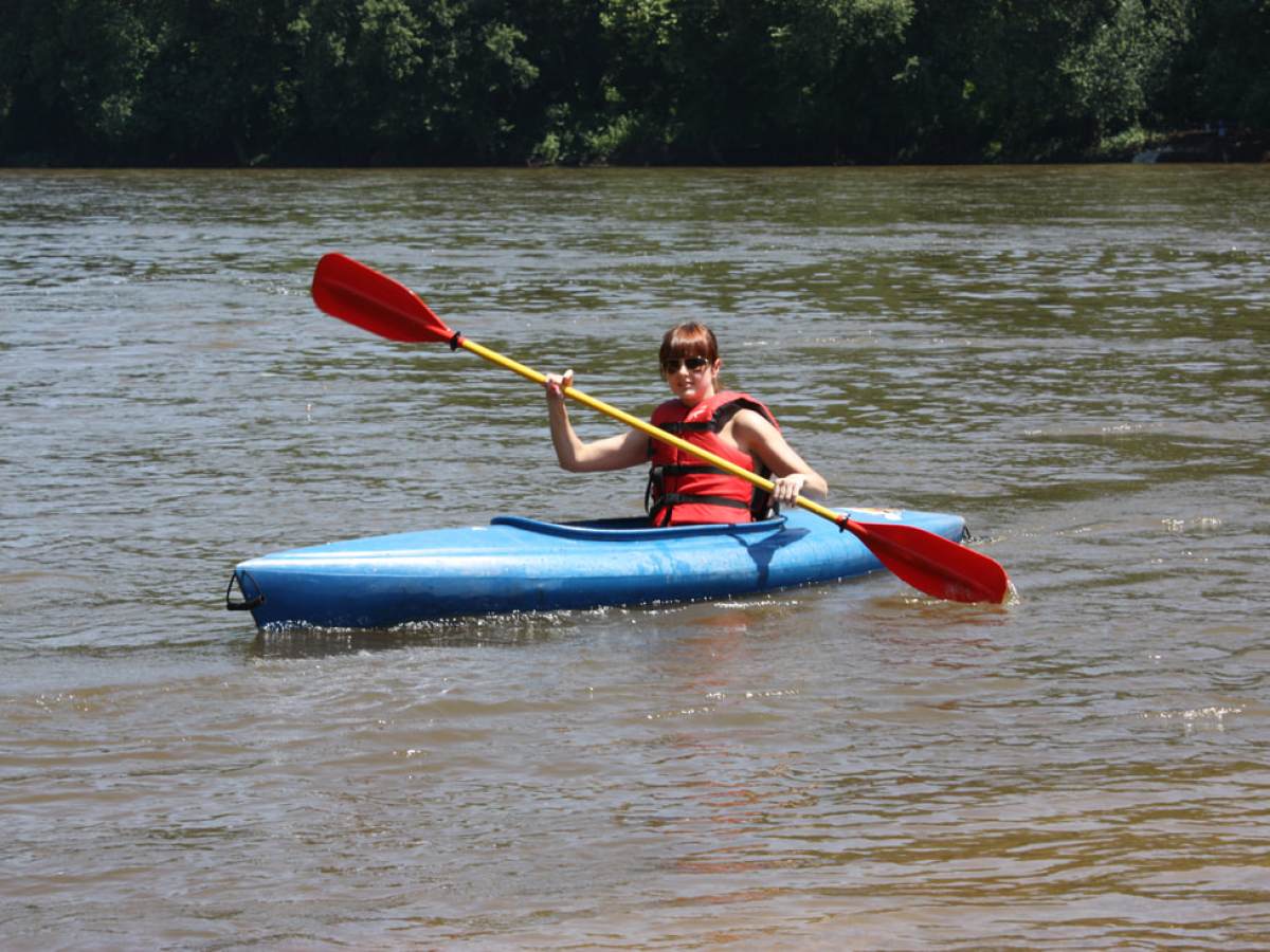 a man riding on the back of a boat in a body of water