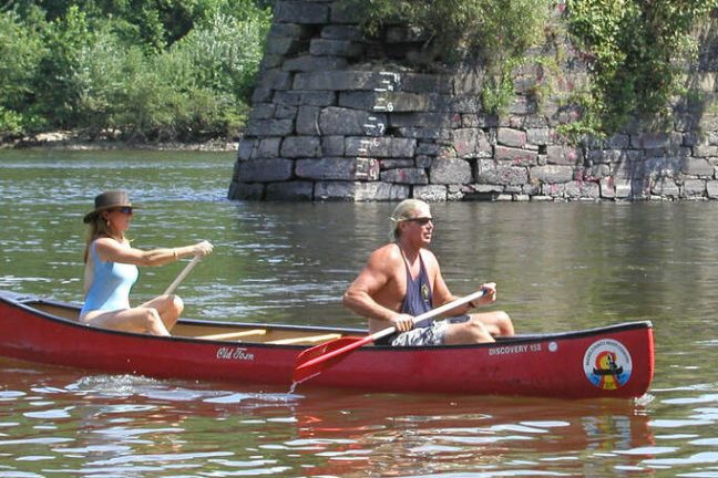 a man riding on the back of a boat in the water