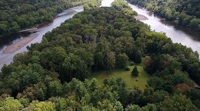 a train traveling through a river surrounded by trees